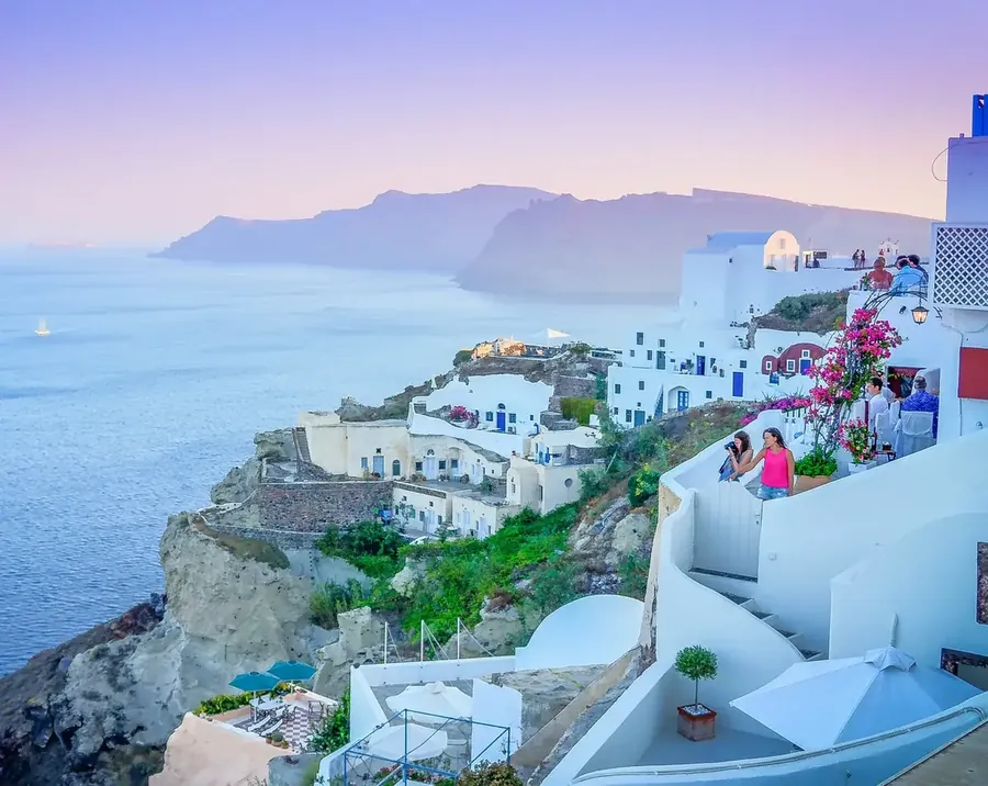 White cliffside houses of Oia, Santorini, above the sea at dusk